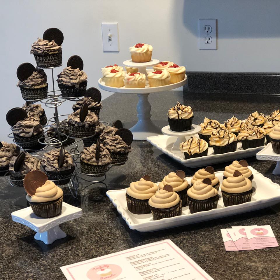 cupcakes on cupcake stands with Cinfully Sweets menu on counter