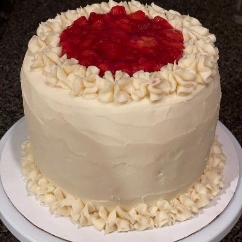 white cake with strawberries on top